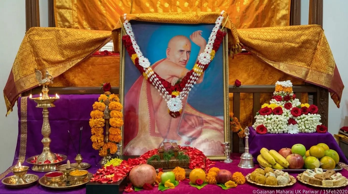Upasana altar with Shree Gajanan Maharaj portrait, flowers, diyas and offerings