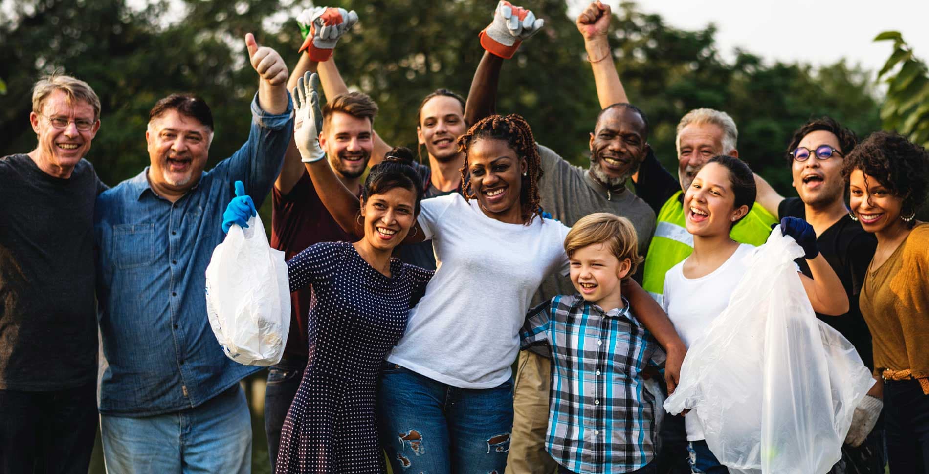 Diverse community volunteers celebrating together outdoors
